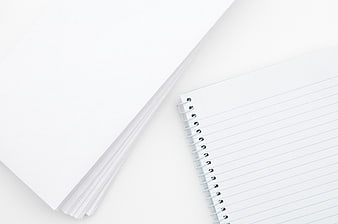 Minimalist white paper stack and spiral notebook on white background