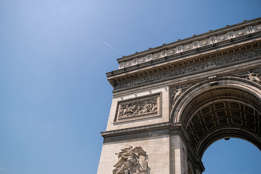 Low angle view of Arc de Triomphe against blue sky