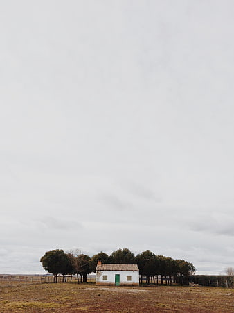 Isolated white house with green door in rural landscape