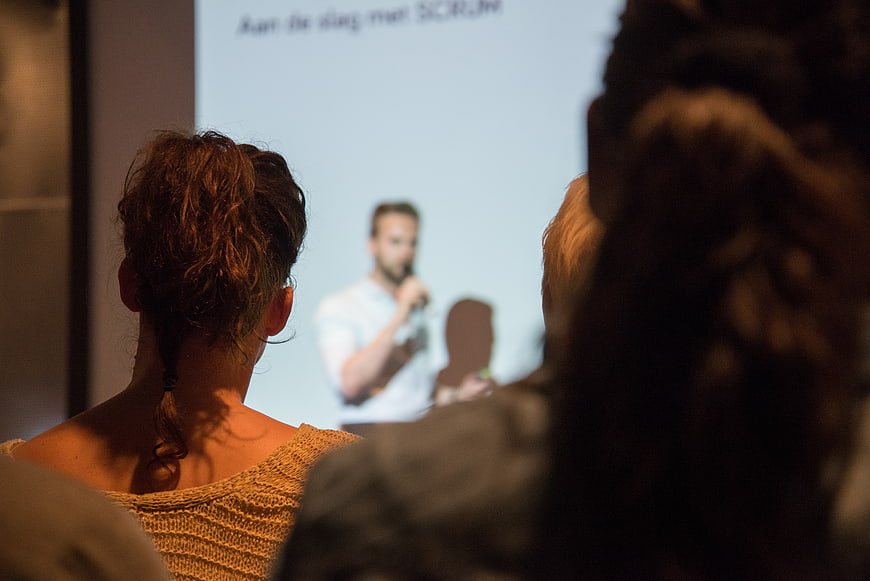 Audience watching a man present at a conference