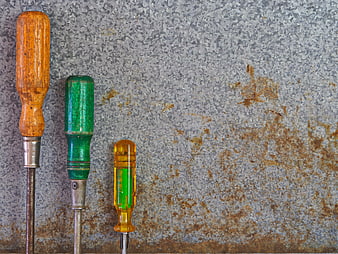 Vintage screwdrivers on rusty metal background with copyspace