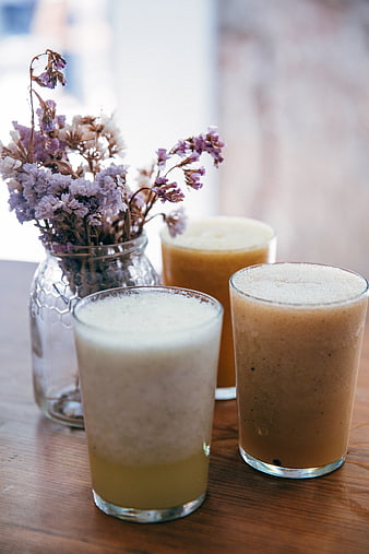 Healthy fruit smoothies and dried flowers on wooden table