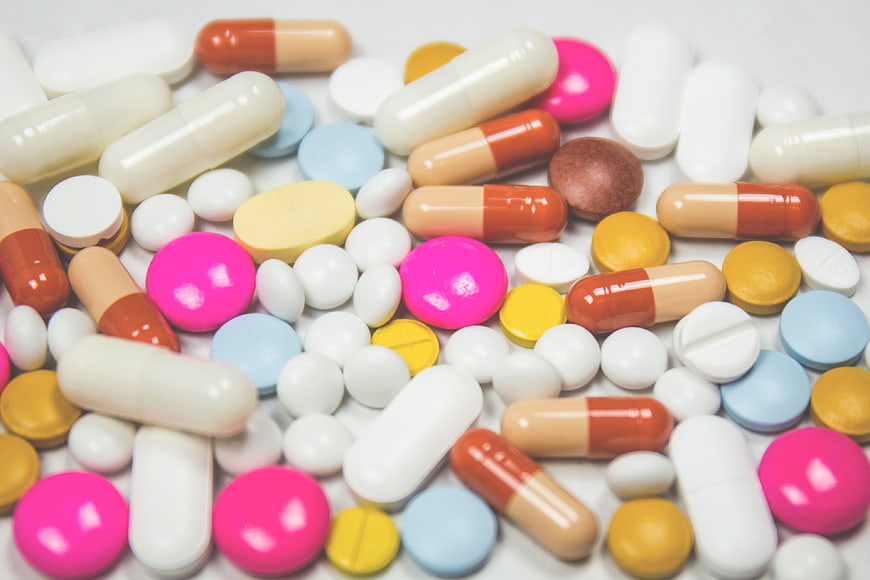 Assorted Colorful Pills and Capsules on White Background