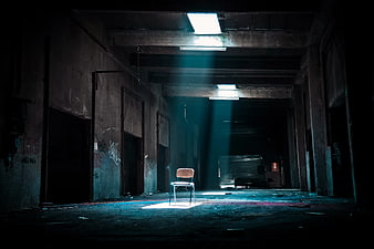 Lone Chair in Dark Abandoned Warehouse with Light Beams