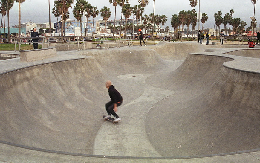 Skateboarder riding concrete bowl at Venice Beach skatepark