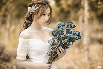 Bride Holding Blue Dried Roses in Forest