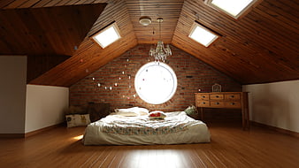 Cozy Attic Bedroom with Wooden Ceiling and Round Window