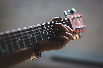 Close-up of woman's hand playing guitar chords