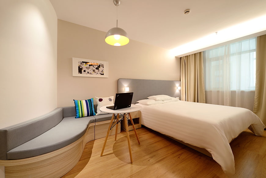 Modern Hotel Room Interior with Bed and Laptop