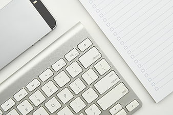 Minimalist Workspace with Keyboard, Smartphone, and Checklist Notepad