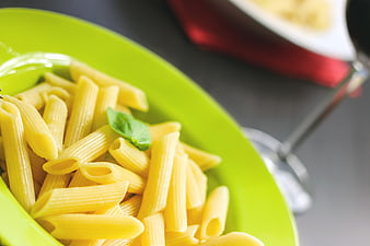 Close-up of plain penne pasta on a green plate