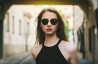 Stylish Woman in Sunglasses Walking Through Urban Archway