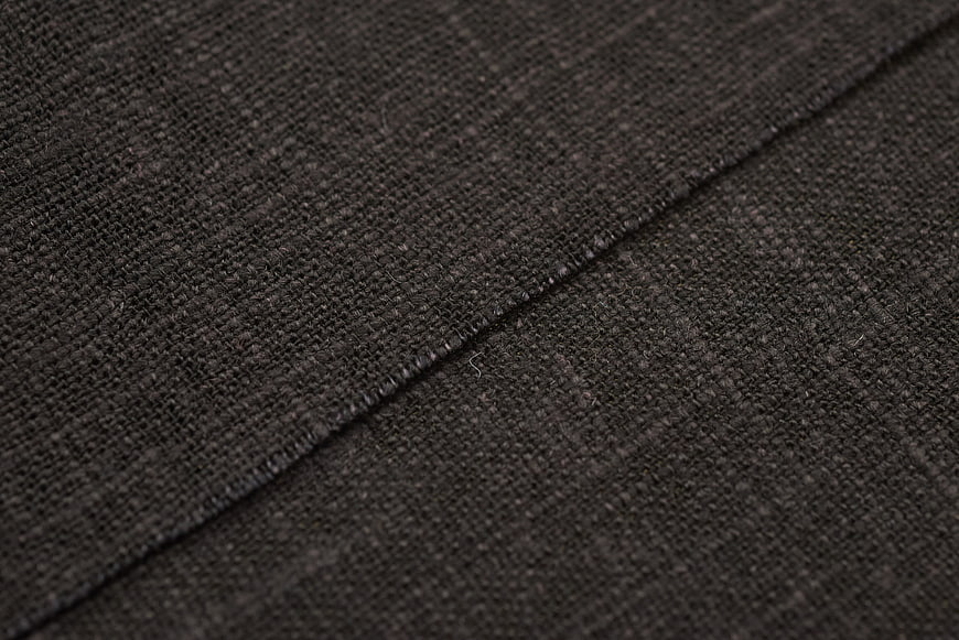 Close-up of dark gray woven fabric texture with stitching detail