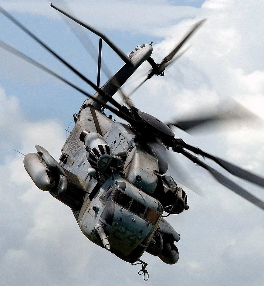 Military Chinook Helicopter in Flight Against Cloudy Sky