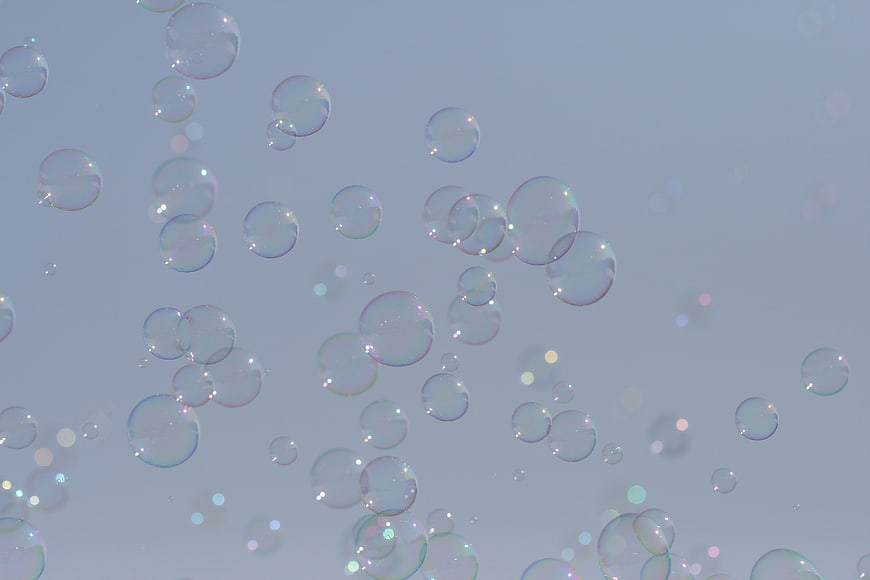 Floating Soap Bubbles with Iridescent Highlights on Soft Blue Background