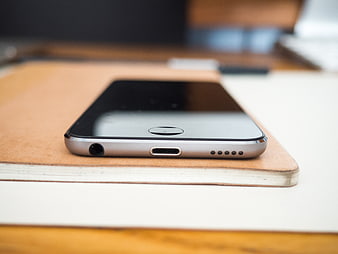 Close-up of Smartphone on Leather Notebook on Desk