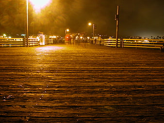 Night view of wooden pier with motion blur and streetlights
