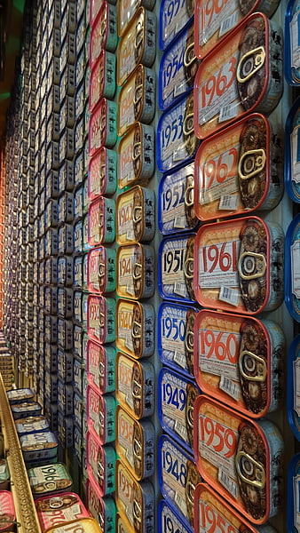 Colorful vintage tins with years stacked on shelves