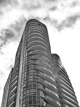 Black and white low angle view of modern curved skyscraper