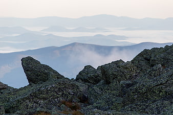 Misty Mountain Landscape with Mossy Rocks and Clouds