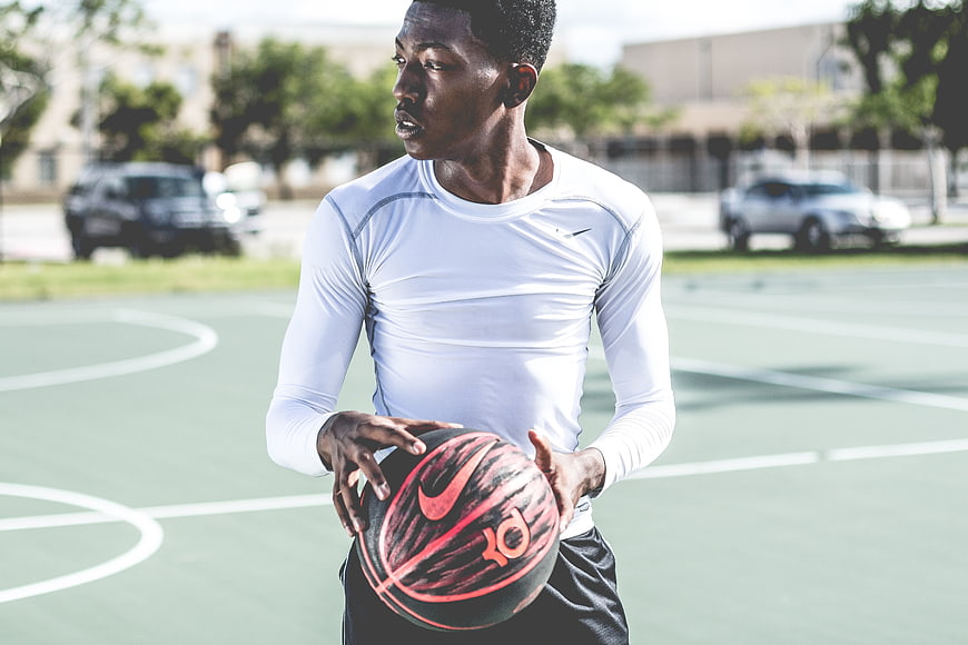 Athletic Man Holding Basketball on Outdoor Court