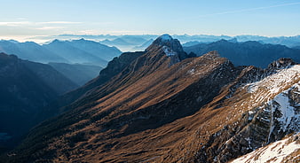 Majestic Mountain Ridge with Snow-Capped Peak and Blue Sky