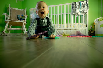 Happy Baby Playing with Foam Shapes on Nursery Floor