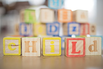 Wooden blocks spelling child on table