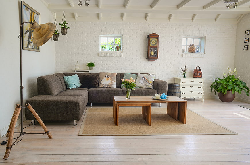Bright rustic living room with white brick walls and wooden furniture
