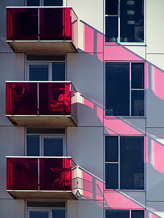Modern Apartment Facade with Red Glass Balconies and Shadows