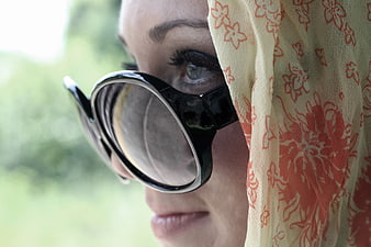 Close-up of woman wearing vintage sunglasses and floral scarf