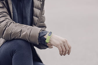 Person wearing green fitness tracker on wrist