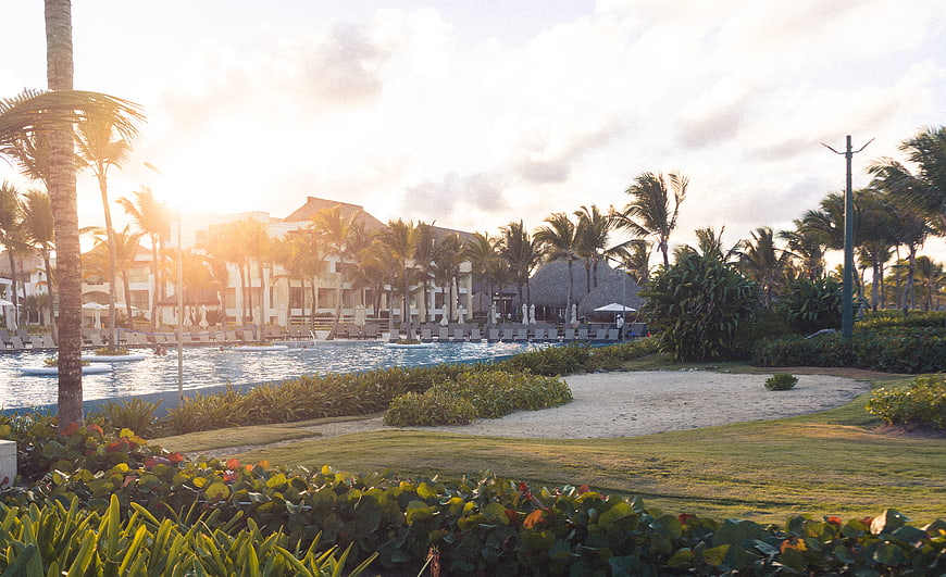 Luxury tropical resort pool at golden hour with palm trees