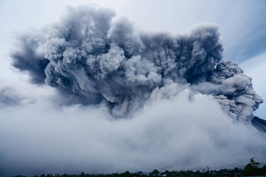 Massive volcanic eruption plume rising into the sky