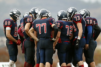 American Football Team Huddle in Navy and Red Uniforms