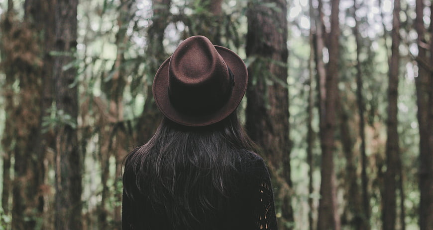 Woman in Fedora Hat Standing in Misty Forest