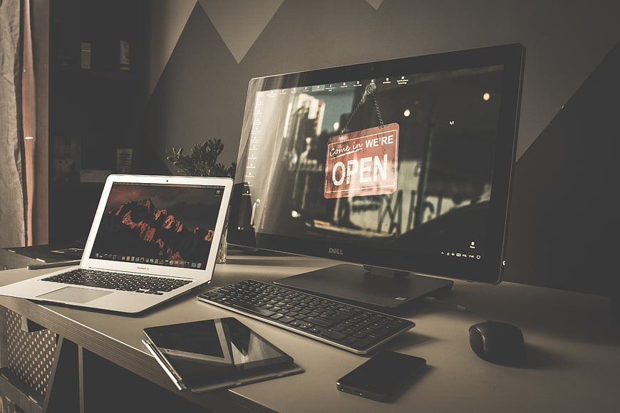 Modern workspace setup with laptop, monitor, and tablet