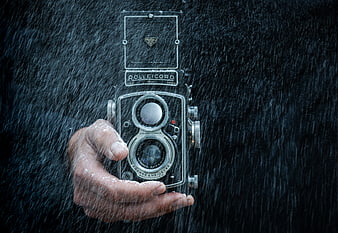 Hand holding vintage Rolleicord camera in rain