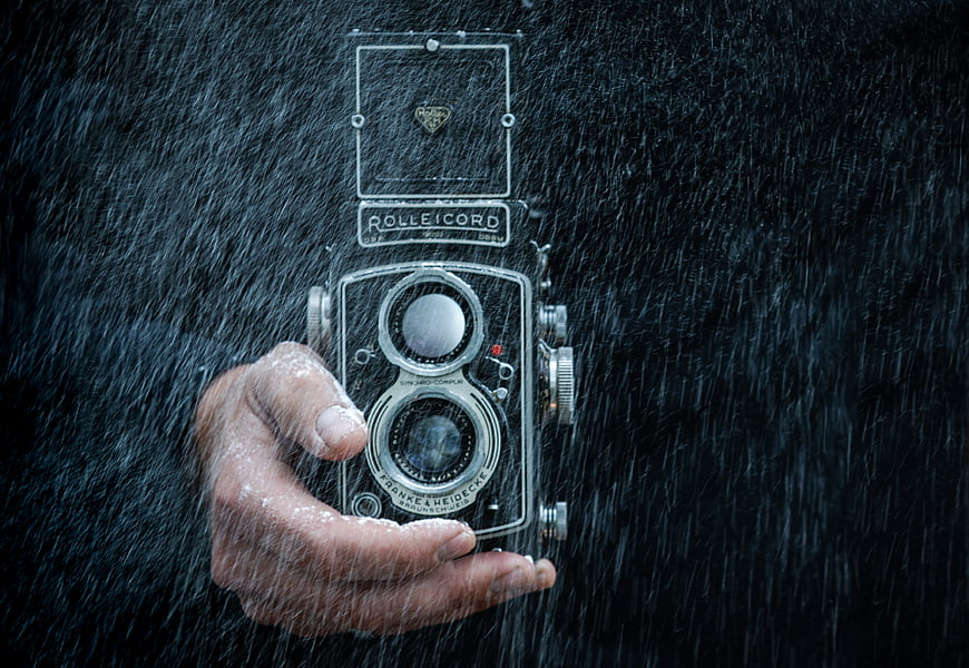 Hand holding vintage Rolleicord camera in rain