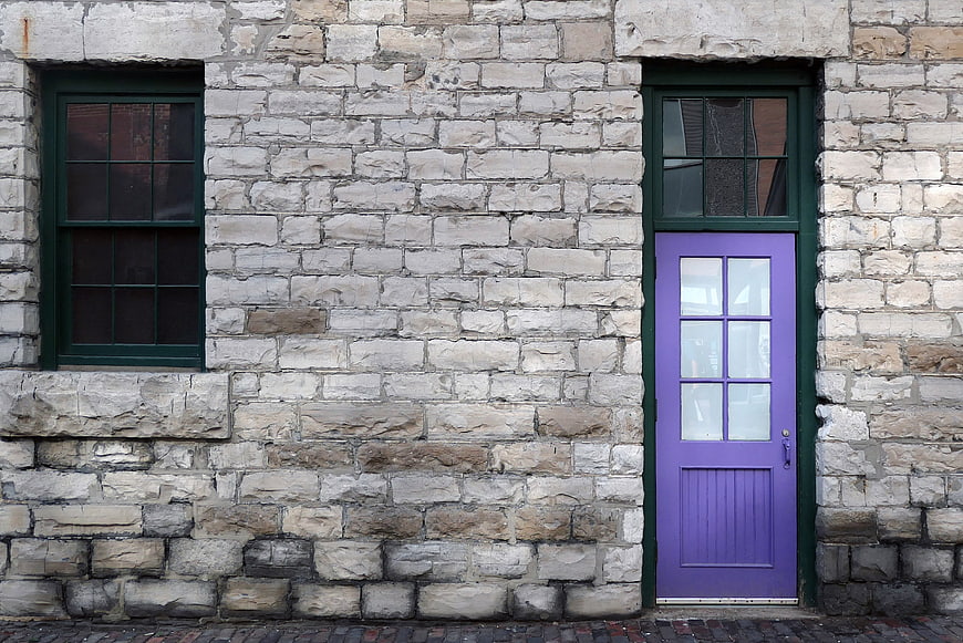 Purple Door on Old Stone Wall with Green Window