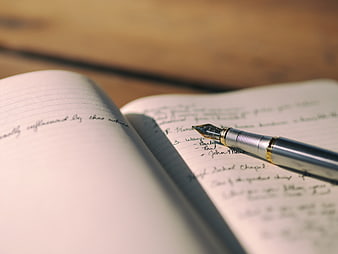 Close-up of fountain pen on handwritten notebook