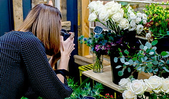 Woman Photographer Taking Pictures of White Roses at Flower Shop