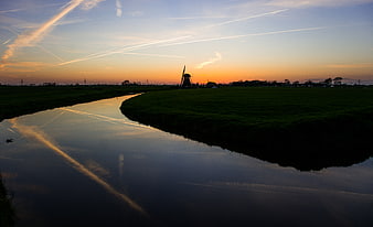 Silhouette of Dutch Windmill at Sunset Over Canal