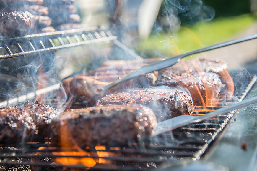 Sizzling Burgers Grilling on Outdoor BBQ with Smoke