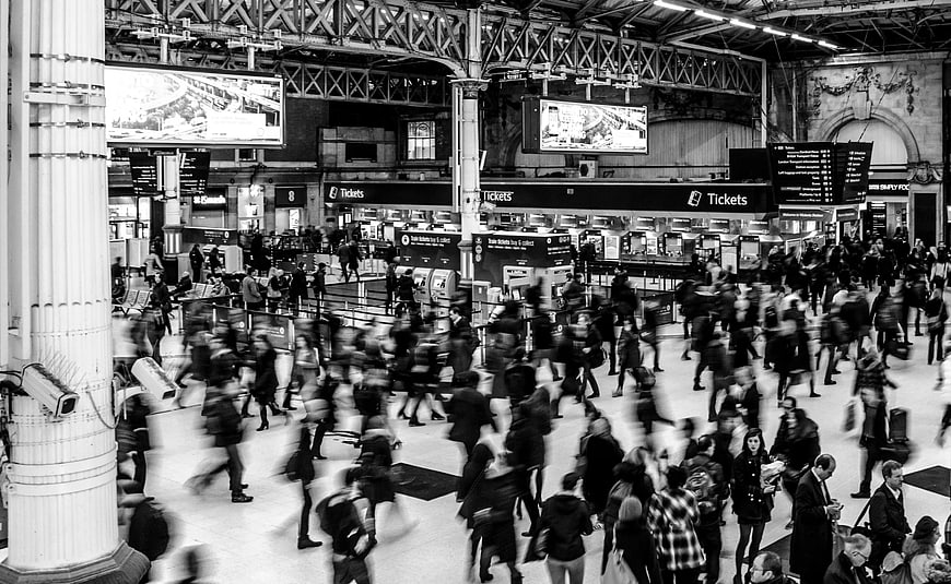 Black and white long exposure of busy train station crowd