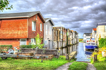 Colorful wooden boat houses along a canal with moored boat