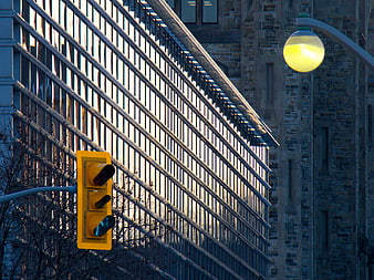 Yellow Traffic Light and Street Lamp Against Urban Architecture