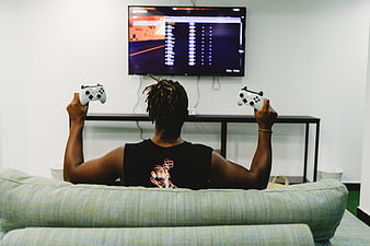 Man playing video games on TV with two controllers
