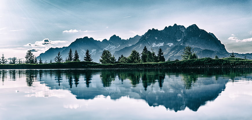 Serene Mountain Lake Reflection with Pine Trees and Peaks