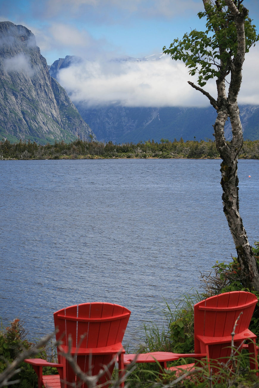 Red Adirondack Chairs by Lake with Mountain View